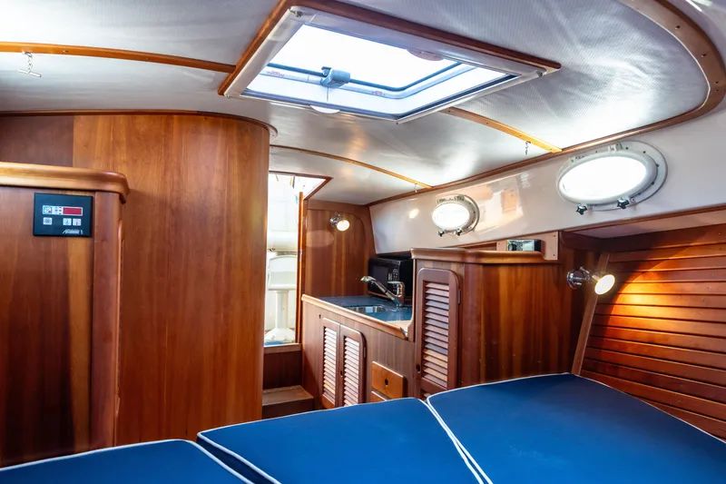 Slide: The Image of Interior of 2007 Hinckley Picnic Boat EP with wood paneling and blue seating. - 41
