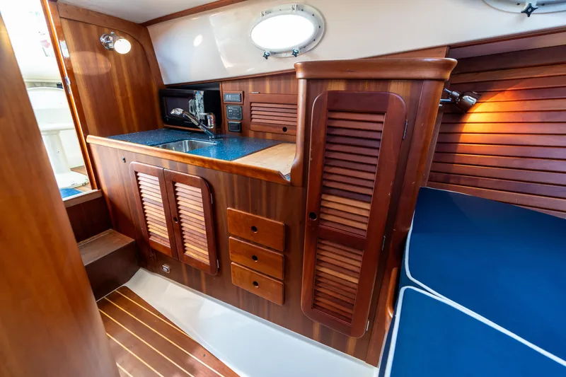 Slide: The Image of 2007 Hinckley Picnic Boat EP interior with wooden cabinetry and blue seating. - 42