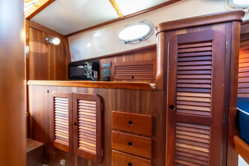 Slide: The Image of Hinckley Picnic Boat EP 2007 interior with wooden cabinetry and porthole window. - 43