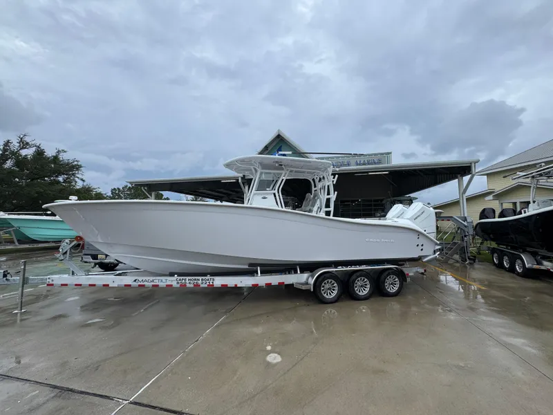 The Image of 2025 Cape Horn 32 XS boat on trailer, parked outside a marine dealership. - 1
