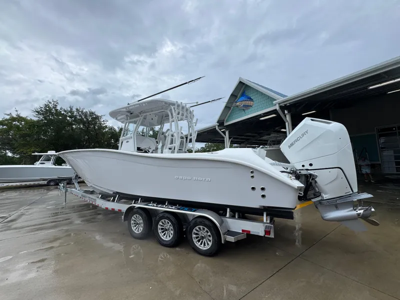 Slide: The Image of 2025 Cape Horn 32 XS boat on trailer, featuring Mercury outboard engines, parked outdoors. - 16