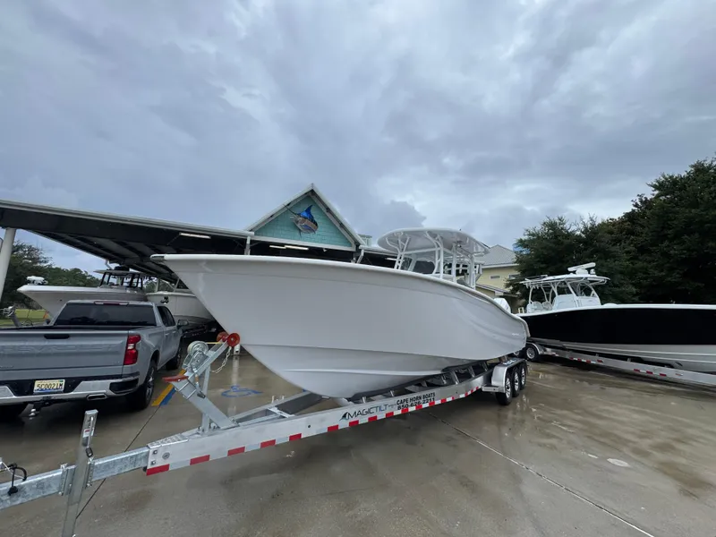 Slide: The Image of 2025 Cape Horn 32 XS boat on trailer, parked outdoors under cloudy sky. - 4