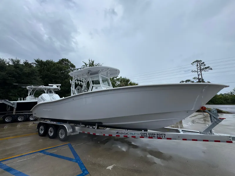 Slide: The Image of 2025 Cape Horn 32 XS boat on trailer, parked outdoors on a cloudy day. - 8