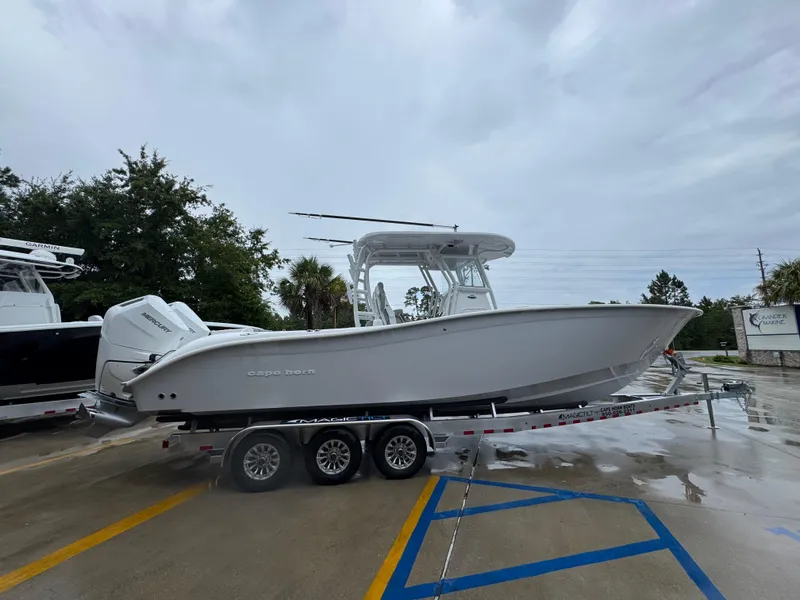 Slide: The Image of 2025 Cape Horn 32 XS boat on trailer, parked outdoors on a cloudy day. - 9