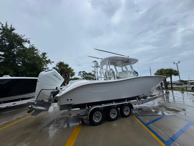 Slide: The Image of 2025 Cape Horn 32 XS boat on trailer, parked outdoors on a wet surface. - 10