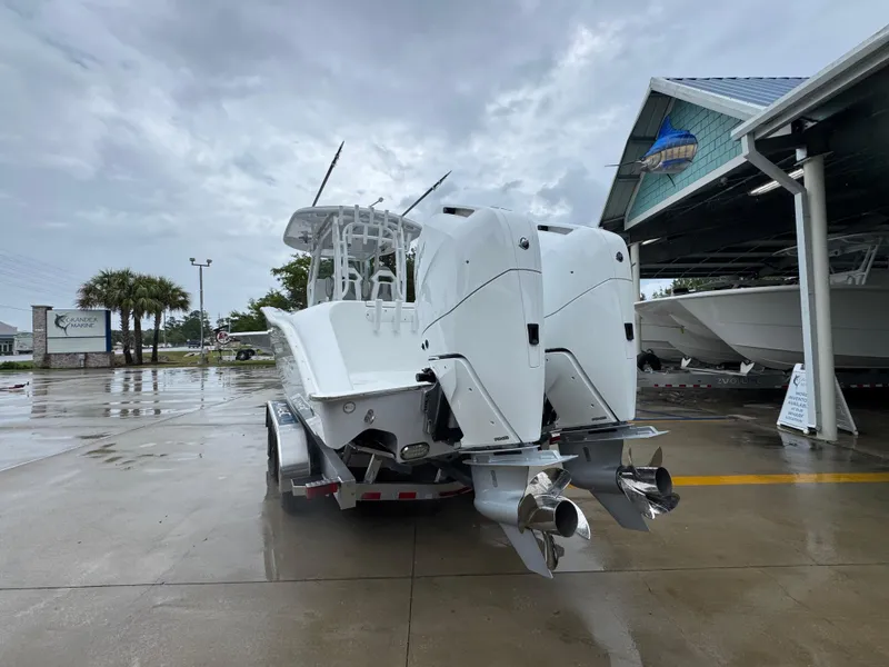 Slide: The Image of 2025 Cape Horn 32 XS boat with dual engines on a trailer, parked outdoors. - 14