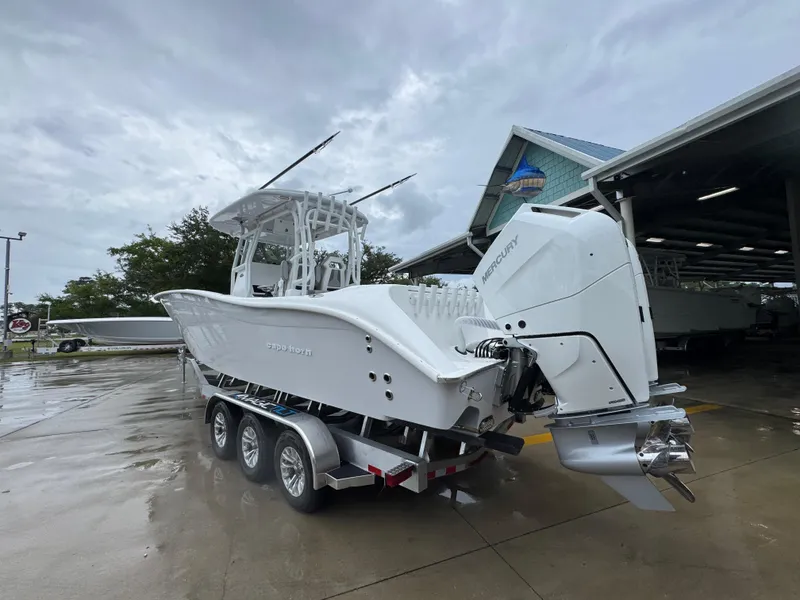 Slide: The Image of 2025 Cape Horn 32 XS boat on trailer, featuring dual Mercury engines, parked outdoors. - 15