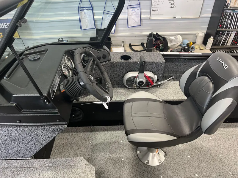 Slide: The Image of 2026 Lund 1800 Explorer Sport boat interior with steering wheel and seat. - 14
