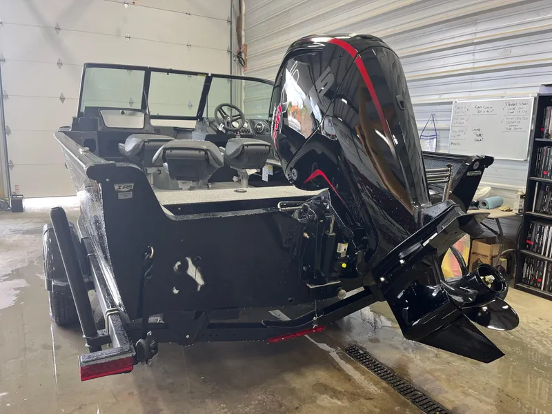 Slide: The Image of 2026 Lund 1800 Explorer Sport boat with powerful outboard motor in a garage setting. - 3