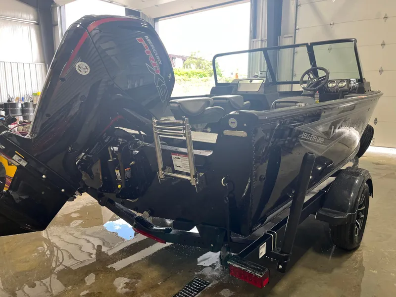 Slide: The Image of 2026 Lund 1800 Explorer Sport boat with Mercury Pro XS engine in a garage. - 5