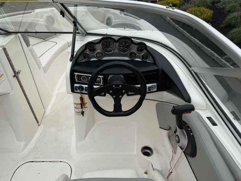 Slide: The Image of Interior view of 2012 Bayliner 235 BR boat cockpit with steering wheel and dashboard controls. - 11