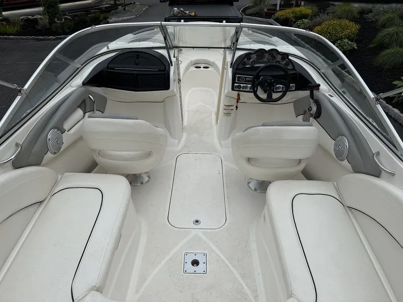 Slide: The Image of 2012 Bayliner 235 BR boat interior with white seating and steering console. - 12