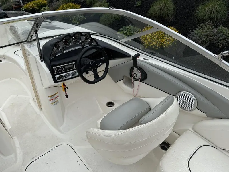 Slide: The Image of Interior of 2012 Bayliner 235 BR boat with steering wheel and dashboard controls. - 16