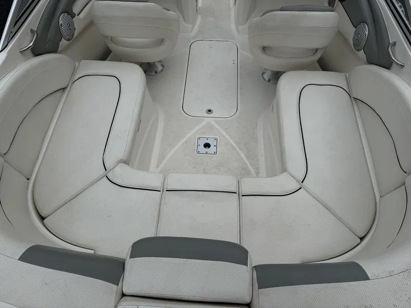 Slide: The Image of 2012 Bayliner 235 BR boat interior with white cushioned seating and sleek design. - 18
