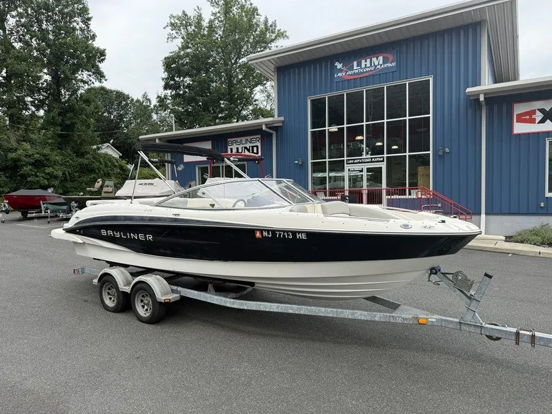 Slide: The Image of 2012 Bayliner 235 BR boat on trailer outside marine dealership. - 4