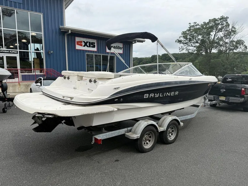 Slide: The Image of 2012 Bayliner 235 BR boat on trailer outside a marine dealership. - 8
