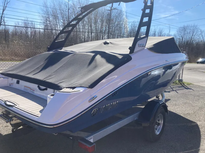Slide: The Image of 2024 Yamaha Boats 195S with cover, displayed on a trailer in a sunny outdoor setting. - 4