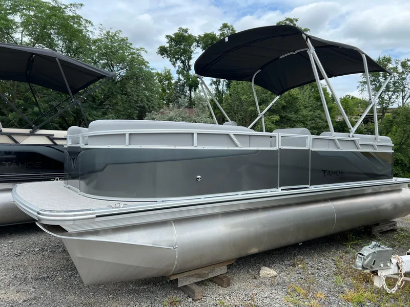 Slide: The Image of 2026 Tahoe Pontoon 2180 boat with canopy, parked on gravel, surrounded by trees. - 4