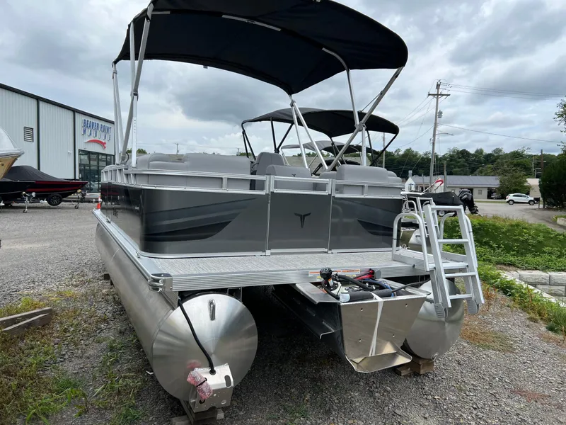 Slide: The Image of 2026 Tahoe Pontoon 2180 boat with canopy, parked outdoors on gravel near dealership. - 5