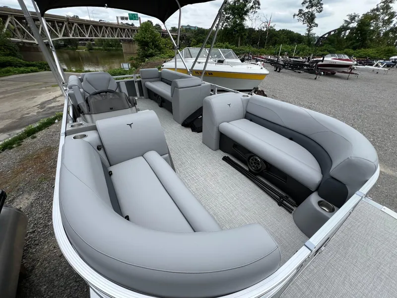 Slide: The Image of 2026 Tahoe Pontoon 2180 with sleek gray seating and spacious deck, docked near a river. - 8