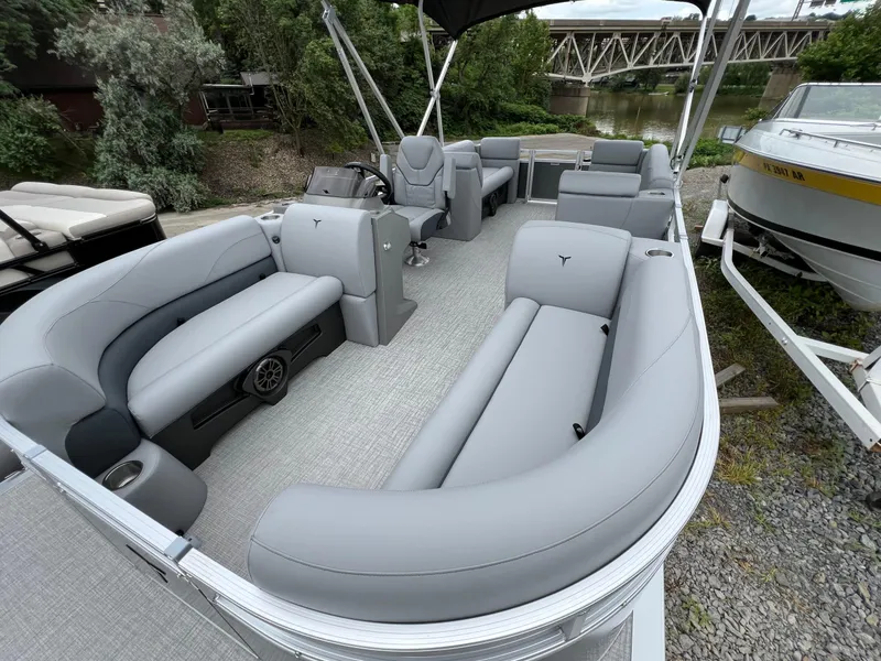 Slide: The Image of 2026 Tahoe Pontoon 2180 with spacious seating and modern design, docked near a river. - 9