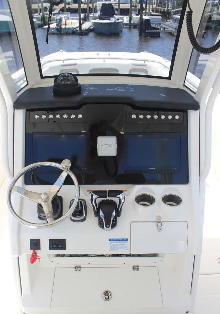 Slide: The Image of 2023 World Cat 280 CC-X boat dashboard with steering wheel and controls. - 19