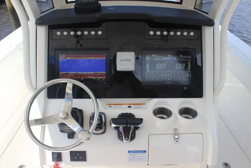 Slide: The Image of 2023 World Cat 280 CC-X boat dashboard with steering wheel and digital displays. - 20