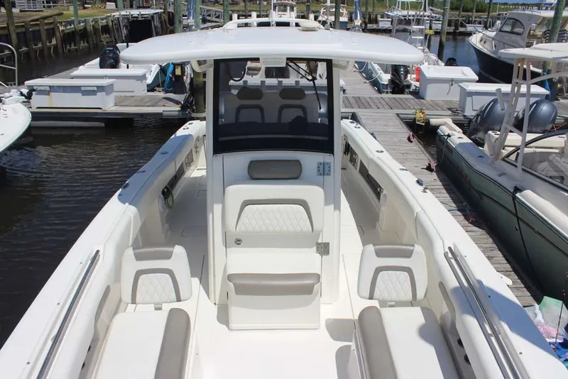 Slide: The Image of 2023 World Cat 280 CC-X boat interior at marina, showcasing seating and helm station. - 8