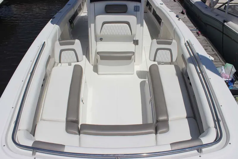 Slide: The Image of 2023 World Cat 280 CC-X boat interior with white and gray seating, docked at marina. - 9