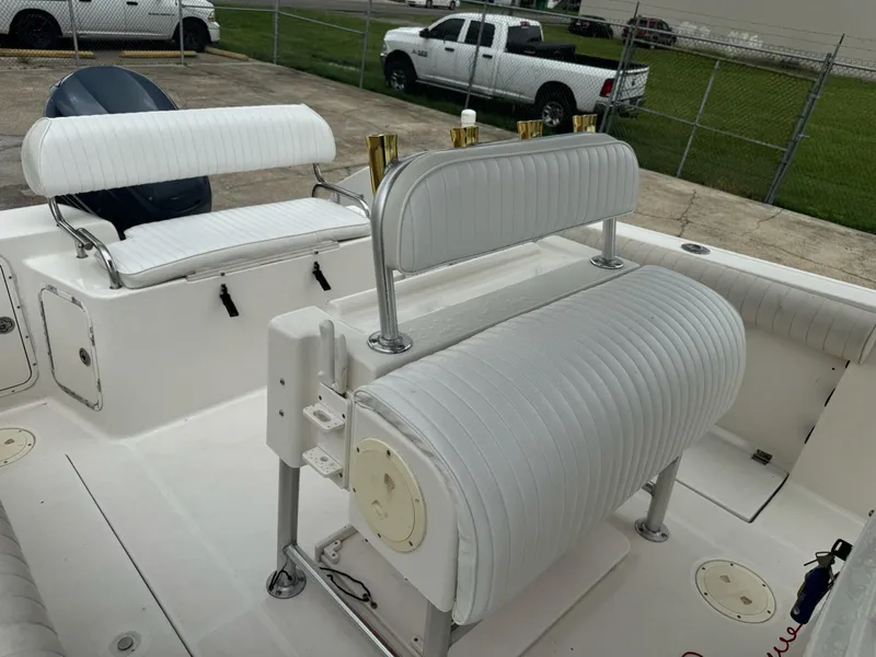 Slide: The Image of 2004 Robalo R230 Center Console boat interior with white cushioned seating. - 19