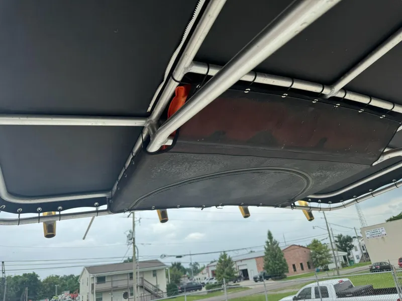 Slide: The Image of T-top of 2004 Robalo R230 Center Console boat with rod holders and storage. - 21