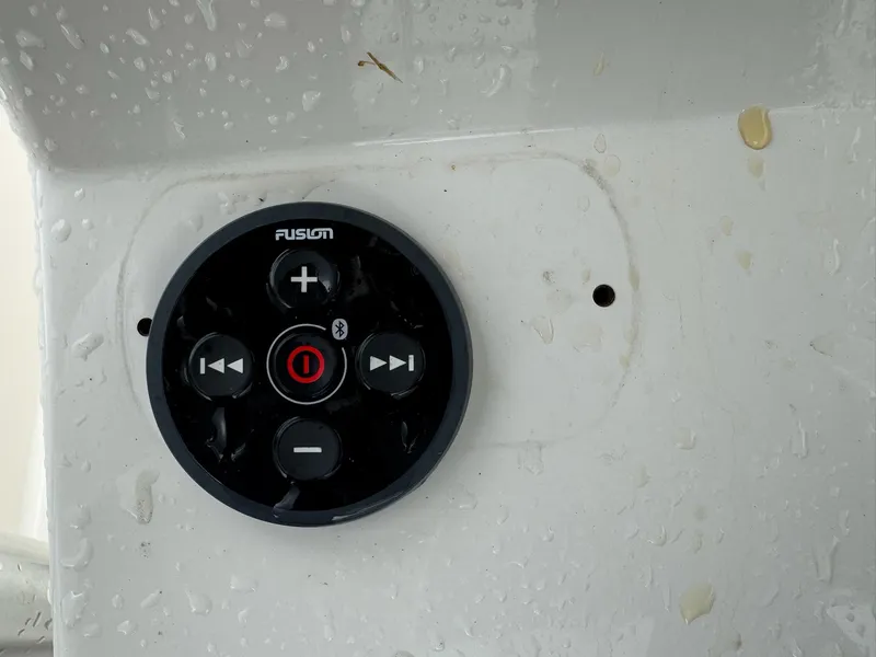 Slide: The Image of Fusion audio control panel on a 2004 Robalo R230 Center Console boat, wet surface. - 25