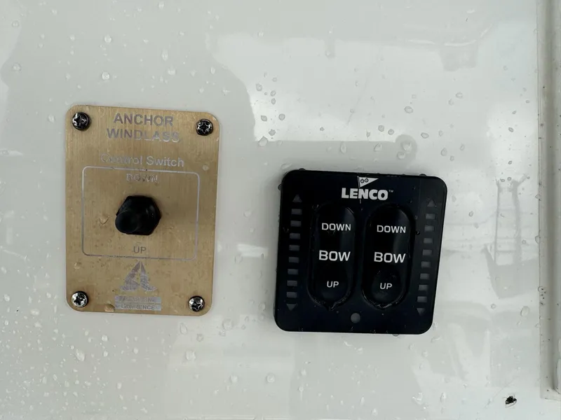 Slide: The Image of Control switches on a 2004 Robalo R230 Center Console boat, featuring anchor windlass and Lenco trim tabs. - 26
