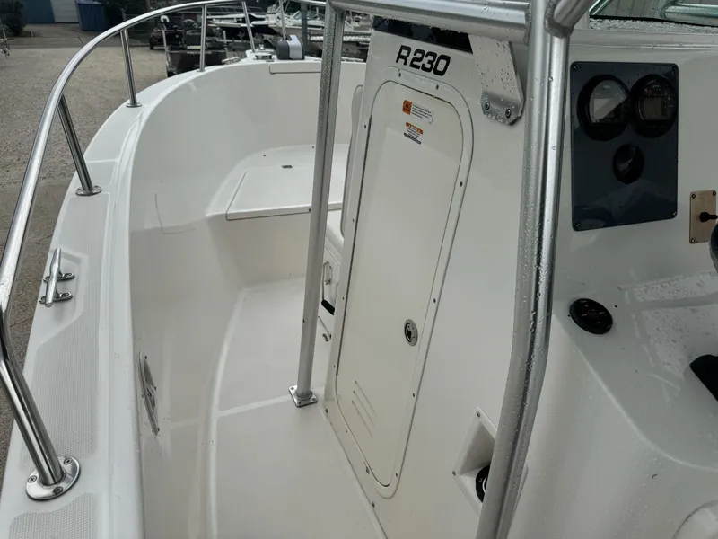 Slide: The Image of 2004 Robalo R230 Center Console boat interior with steering console and seating area. - 29