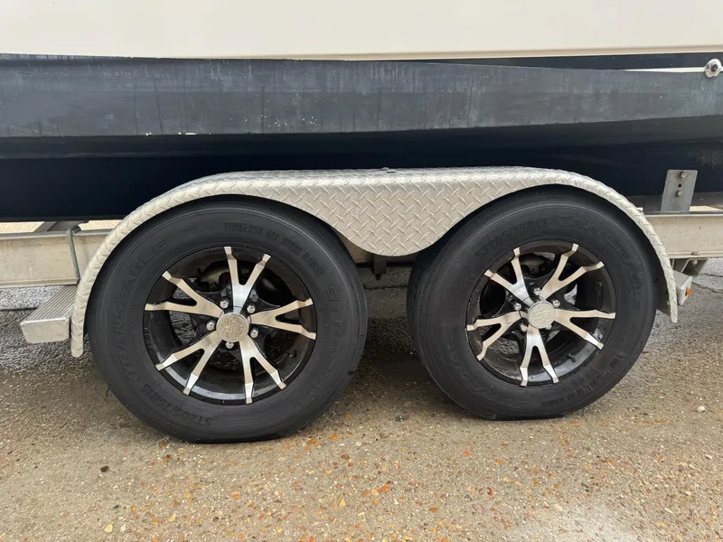 Slide: The Image of Trailer wheels of a 2004 Robalo R230 Center Console boat on a wet surface. - 40