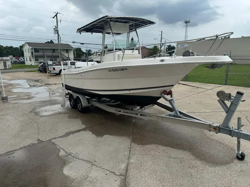 Slide: The Image of 2004 Robalo R230 Center Console boat on trailer, parked outdoors on a cloudy day. - 7