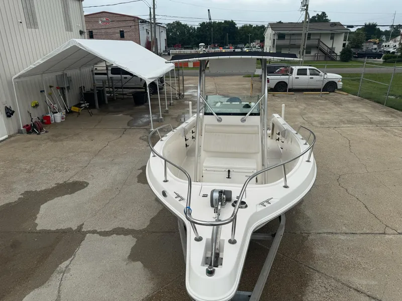 Slide: The Image of 2004 Robalo R230 Center Console boat parked in a concrete lot near a white canopy. - 8