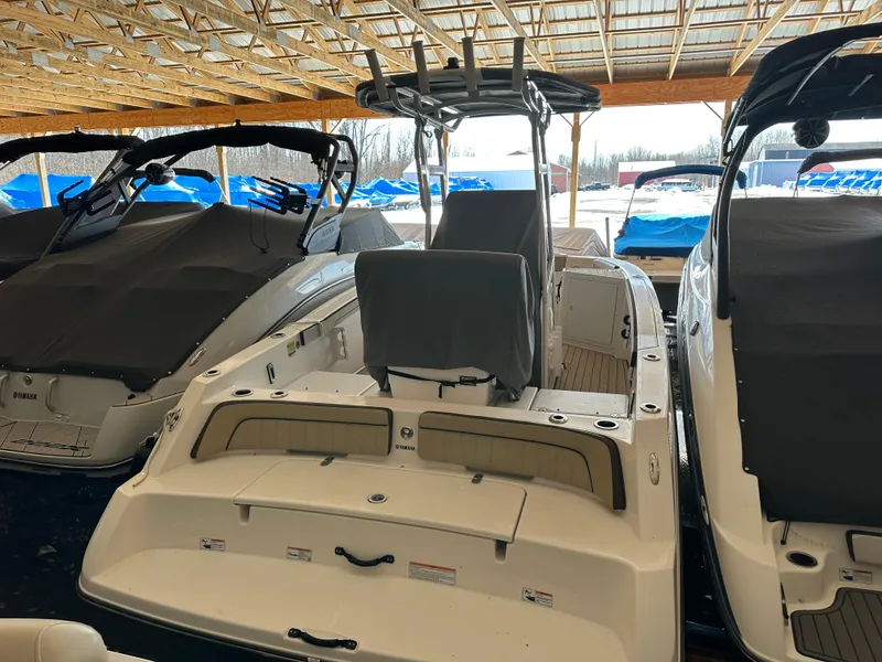 Slide: The Image of 2022 Yamaha Boats 210 FSH Sport in storage, covered, with other boats nearby. - 12