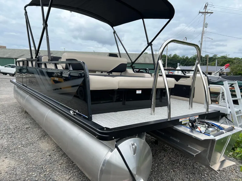 Slide: The Image of 2026 Tahoe Pontoon 2385 VRB with canopy, sleek design, and comfortable seating on gravel lot. - 5