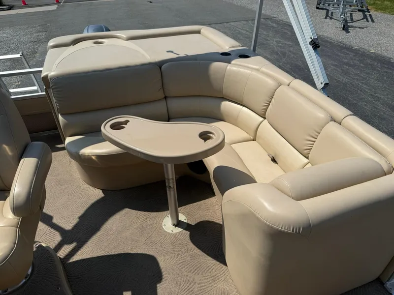 Slide: The Image of 2009 Bennington 2275QXi boat interior with beige seating and a small table. - 10