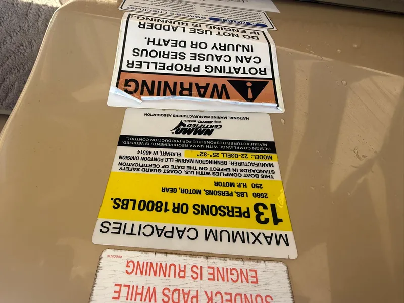 Slide: The Image of Warning labels on a 2009 Bennington 2275QXi boat, indicating safety and capacity limits. - 15