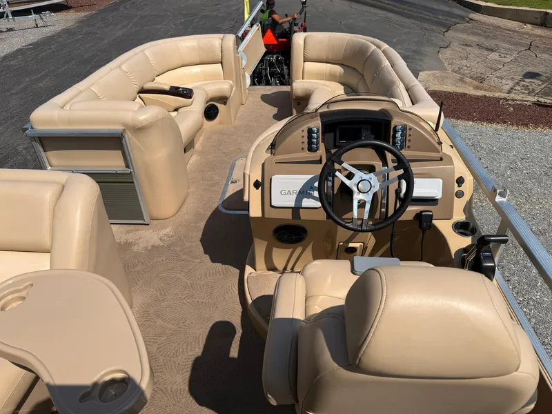 Slide: The Image of 2009 Bennington 2275QXi pontoon boat interior with beige seating and Garmin navigation system. - 19
