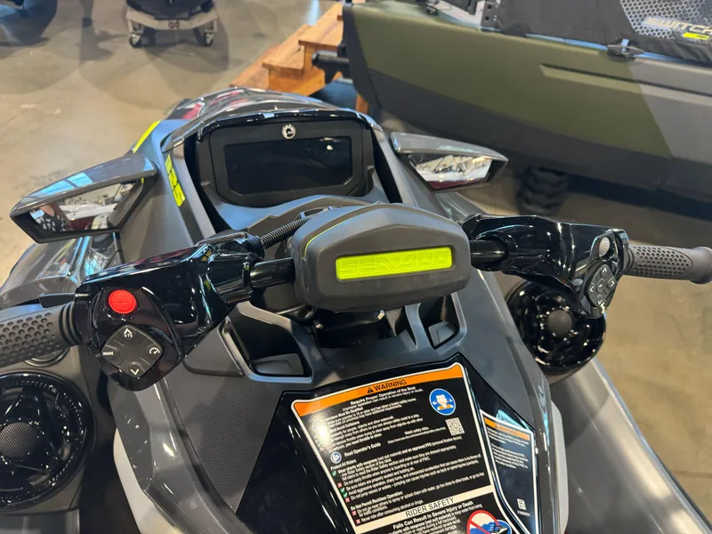 Slide: The Image of 2025 Sea-Doo RXT-X 325 handlebars and dashboard, featuring control buttons and safety warnings. - 5
