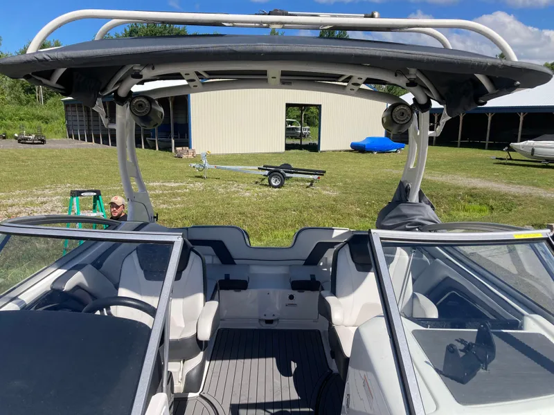 Slide: The Image of 2017 Yamaha Boats 242 Limited S E-Series interior with open cockpit and seating, parked outdoors. - 20
