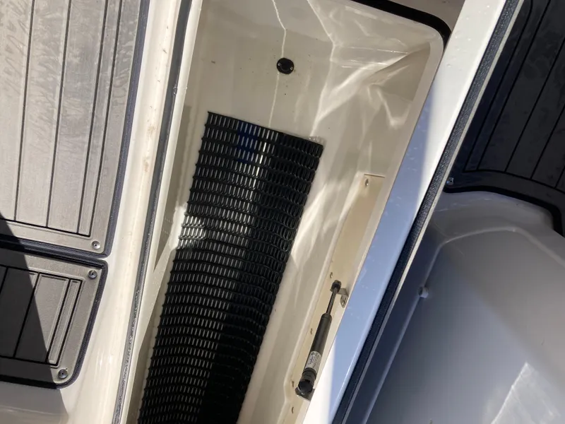 Slide: The Image of 2017 Yamaha Boats 242 Limited S E-Series storage compartment with black mat and hydraulic lift. - 21