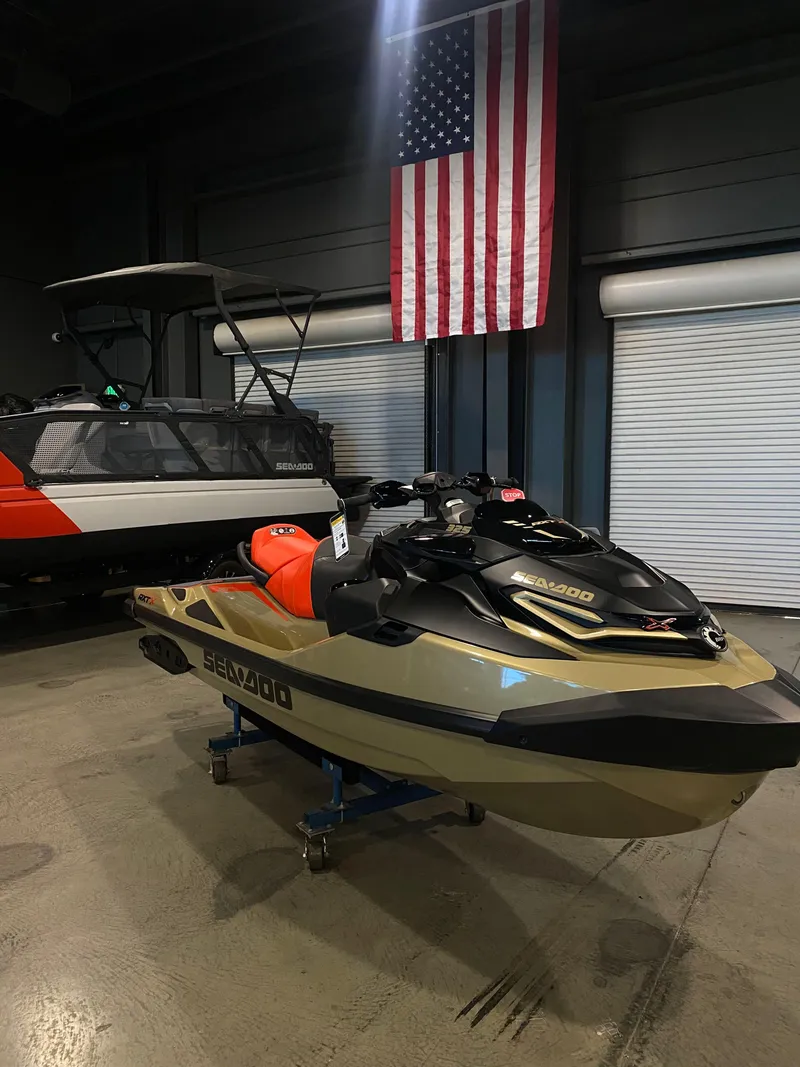 Slide: The Image of 2025 Sea-Doo RXT-X 325 jet ski displayed indoors with American flag backdrop. - 5