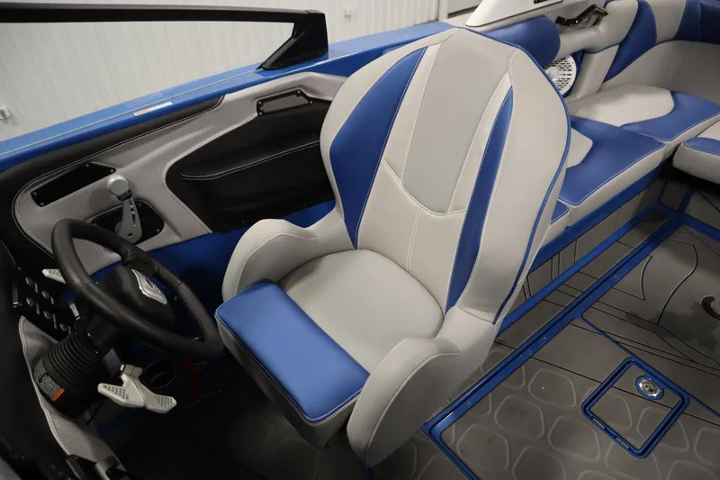 Slide: The Image of 2025 Centurion Fe23 boat interior with blue and gray seating, steering wheel, and controls. - 27
