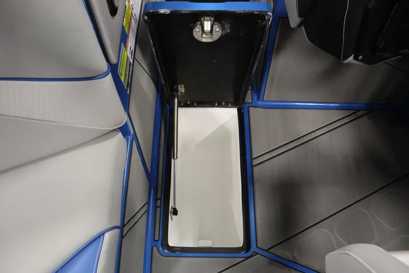 Slide: The Image of Open storage compartment in 2025 Centurion Fe23 boat interior, featuring blue and gray accents. - 33