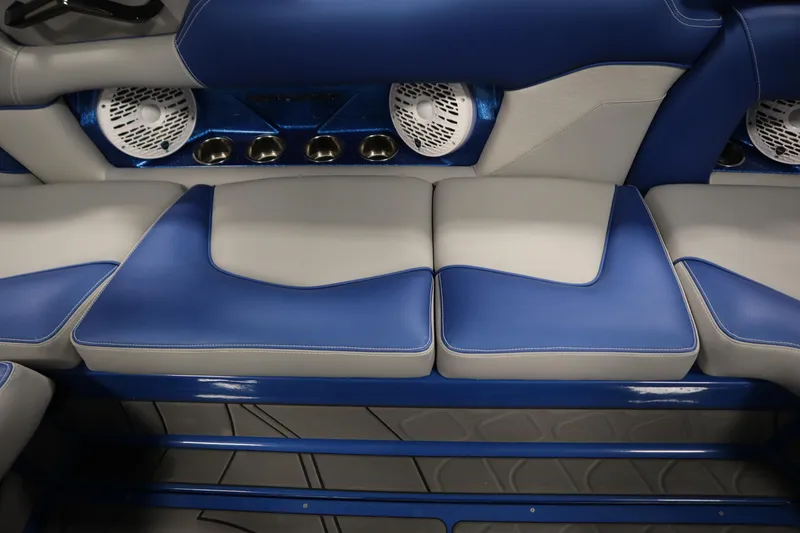 Slide: The Image of 2025 Centurion Fe23 boat interior with blue and gray seating, speakers, and cup holders. - 39