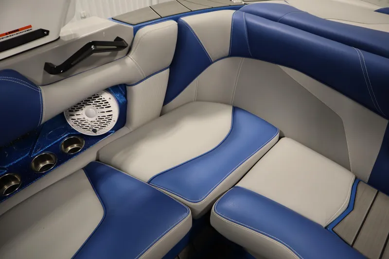 Slide: The Image of 2025 Centurion Fe23 boat interior with blue and gray seating, cup holders, and speaker. - 47